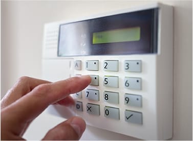 A person pressing the button on a home security system
